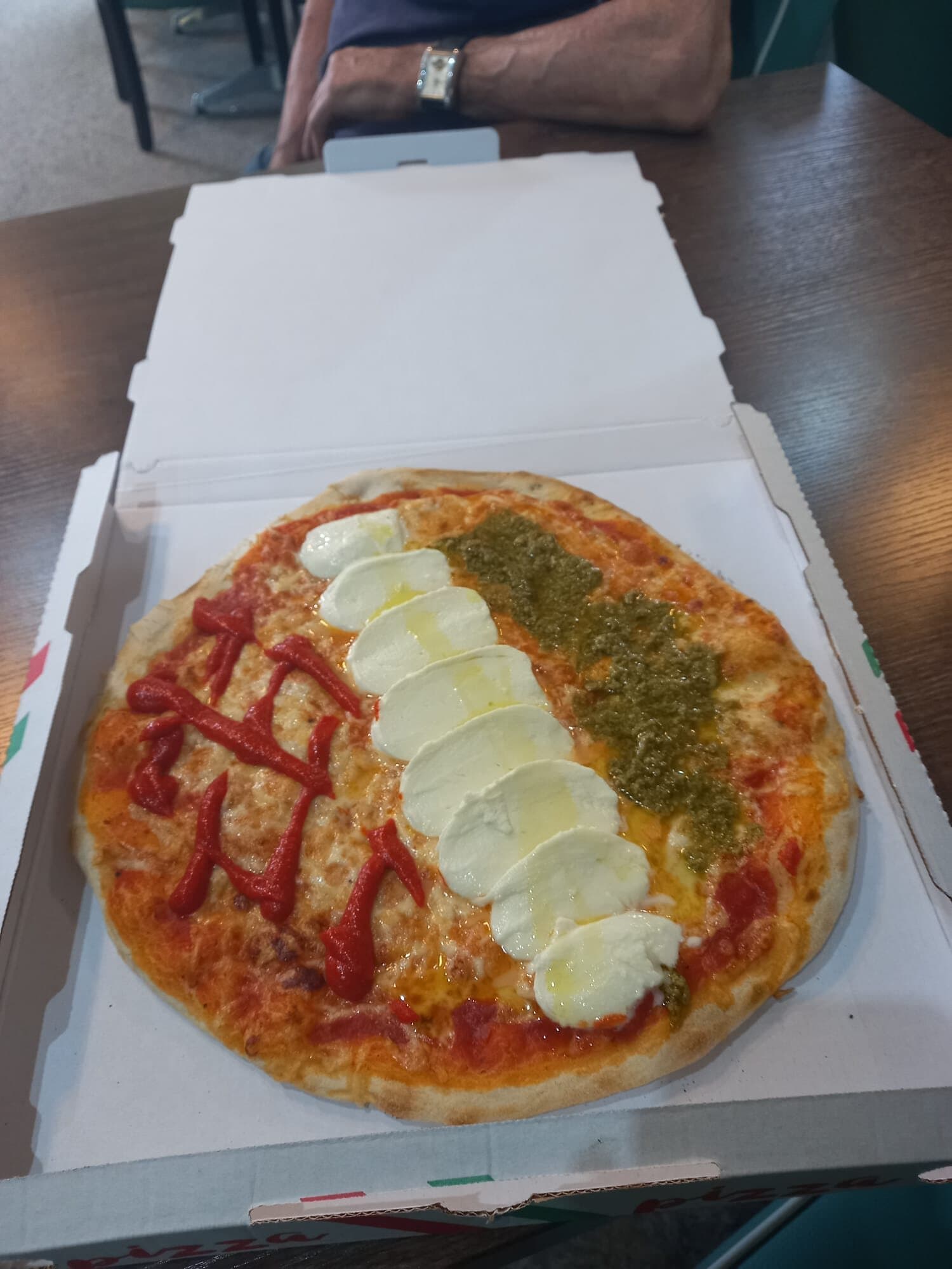 Pizza aus dem Steinofen der Bistrorante La Pizzeria — Tomate, Mozzarella in Scheiben und Pesto